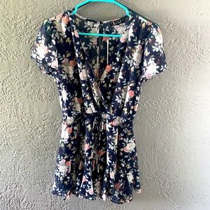 Navy blue romper with white & plink floral design.